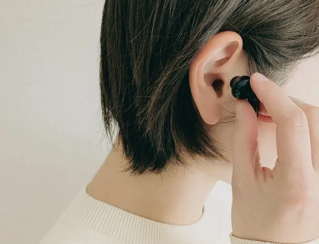 ワイヤレスイヤフォンでオーディブルを聞く女性