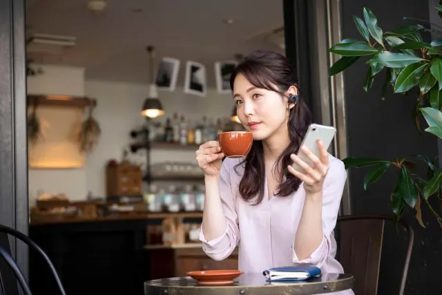 カフェでオーディブルを聞く女性